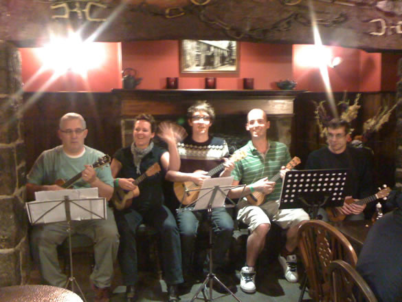 Bangor Uke Club (from left to right - Pete, Jane, Matt, Doug and Simon) preparing to play in the fireplace of the Vaynol Arms in Nant Peris