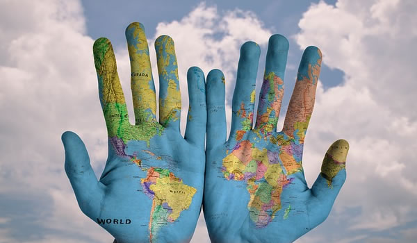 A photo of hand with the world painted on them